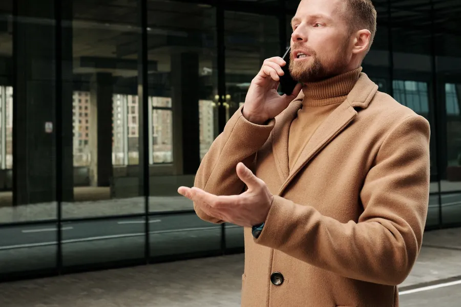 Un hombre gesticulando mientras habla por teléfono en la calle